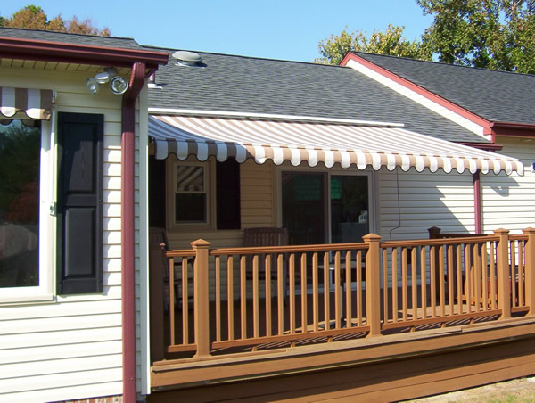 A retractable awning the a deck of a house.