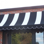 A striped awning on a commercial store front.